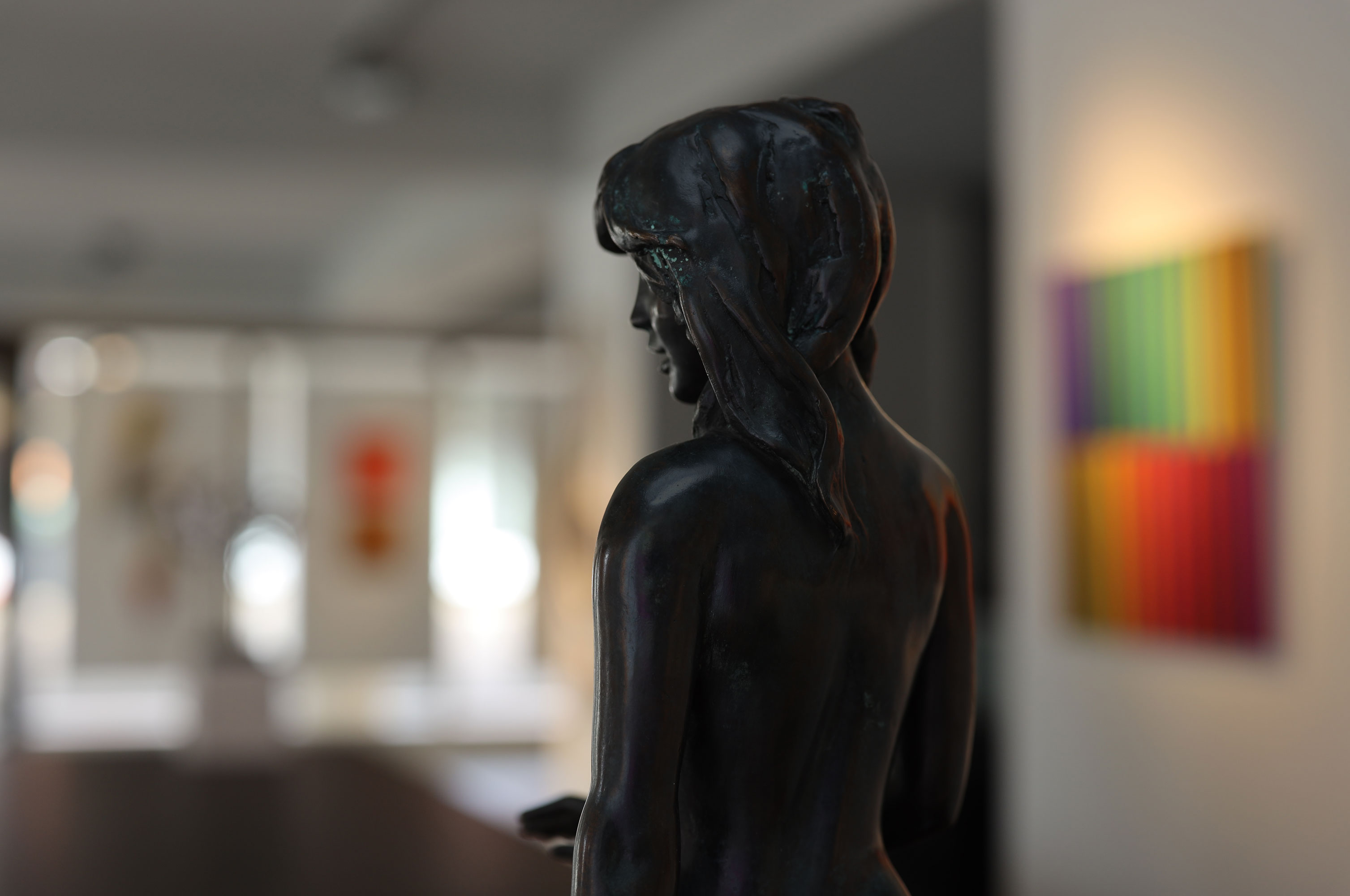 Der Blick über die Schulter einer Skulptur in einen Ausstellungsraum